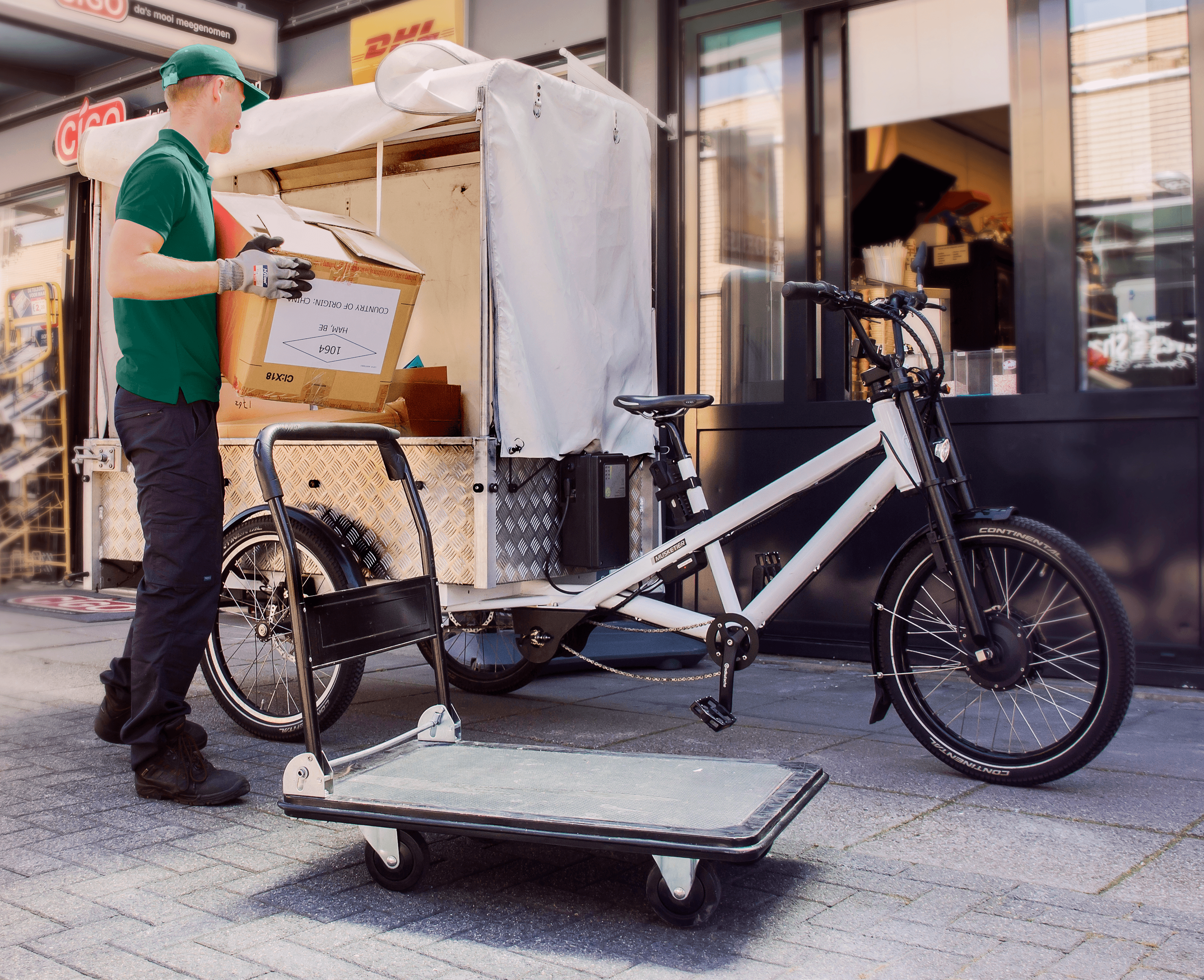 Foto van een man die afval in elektrische bakfiets stopt